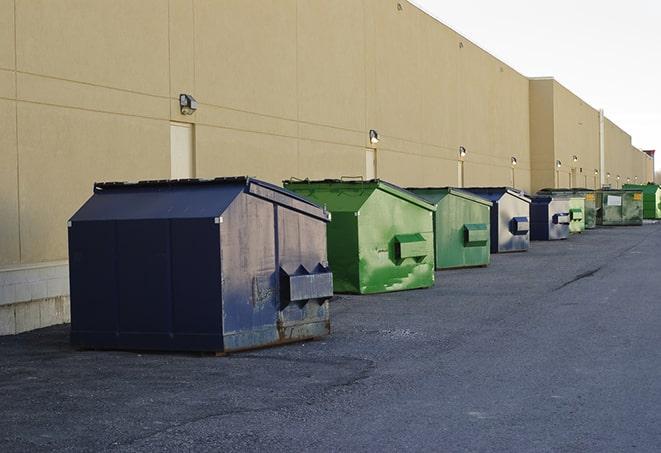 a construction worker empties a wheelbarrow of waste into the dumpster in Gaffney